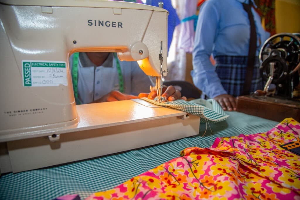 Pupil using a Singer sewing machine