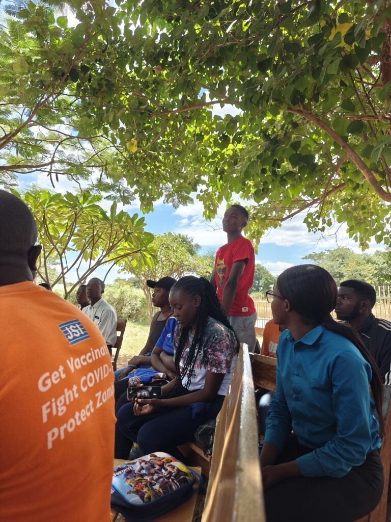 Young person standing up speaking to youth/health Indaba 2025